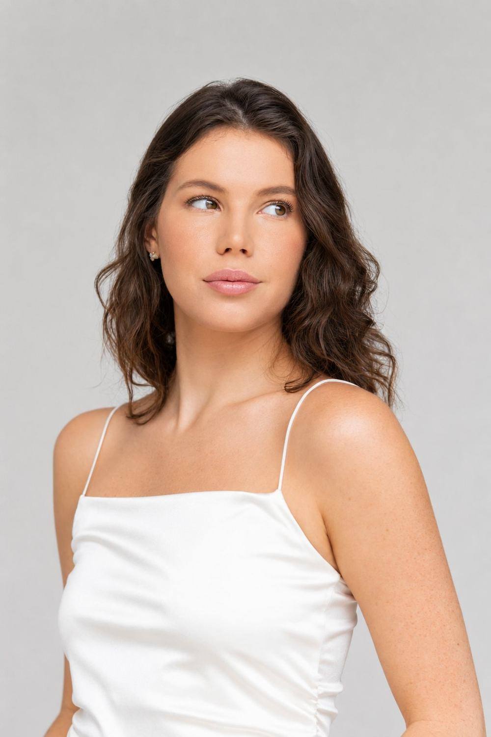 Headshot, white satin top, looking over shoulder